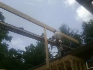 Carpenter setting a ridge beam over a new addition frame — Ice Dam Removal by Roofing Brothers in Chagrin Falls