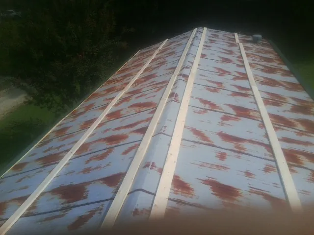 Rusted metal roof panels with new wood purlins before replacement — Storm Damage Roof Repair in Chagrin Falls by Roofing Brothers
