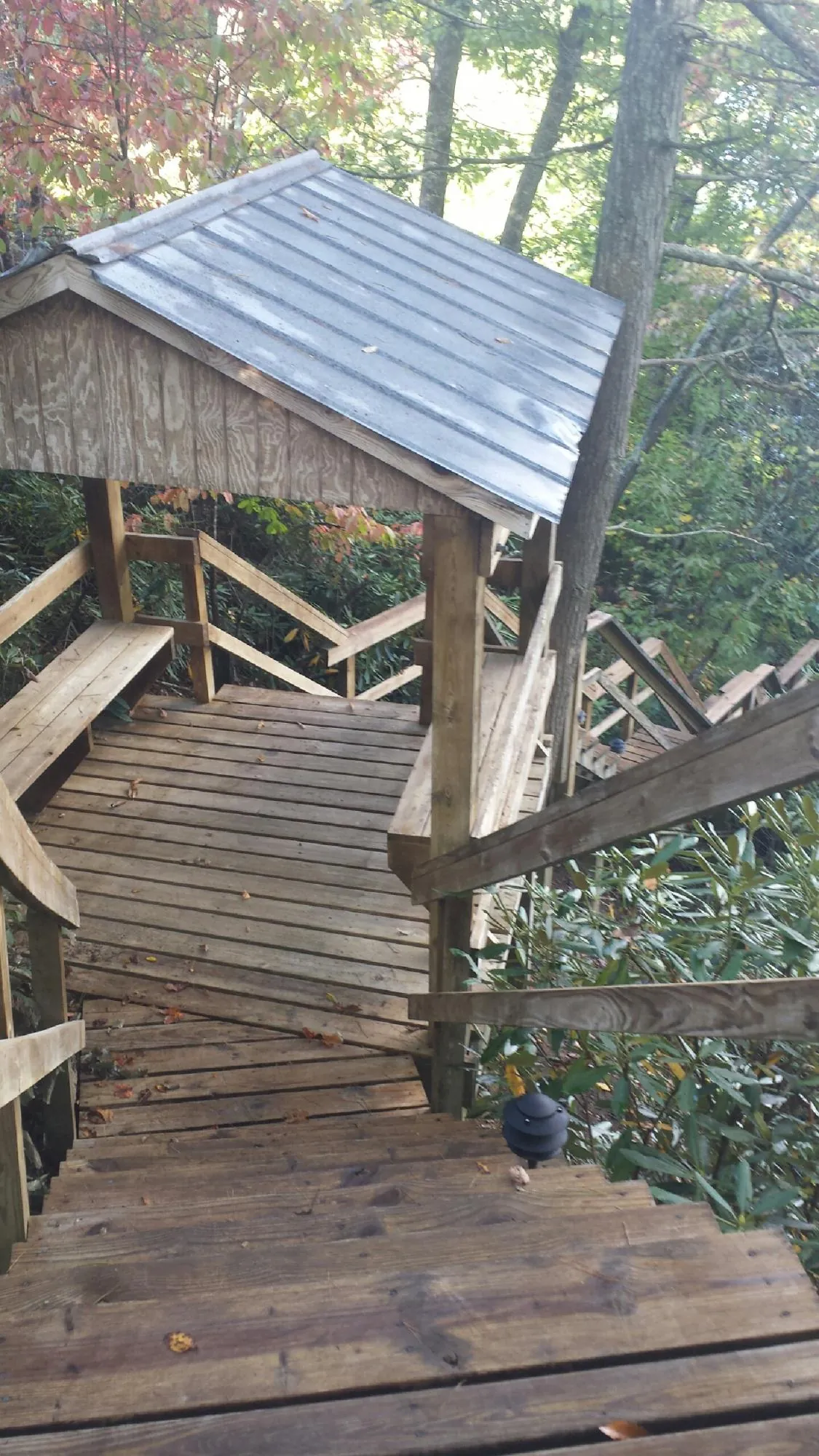 Metal roofed shelter over wooden steps on a wooded walkway — Skylight Repair & Installation work by our crew in Chagrin Falls
