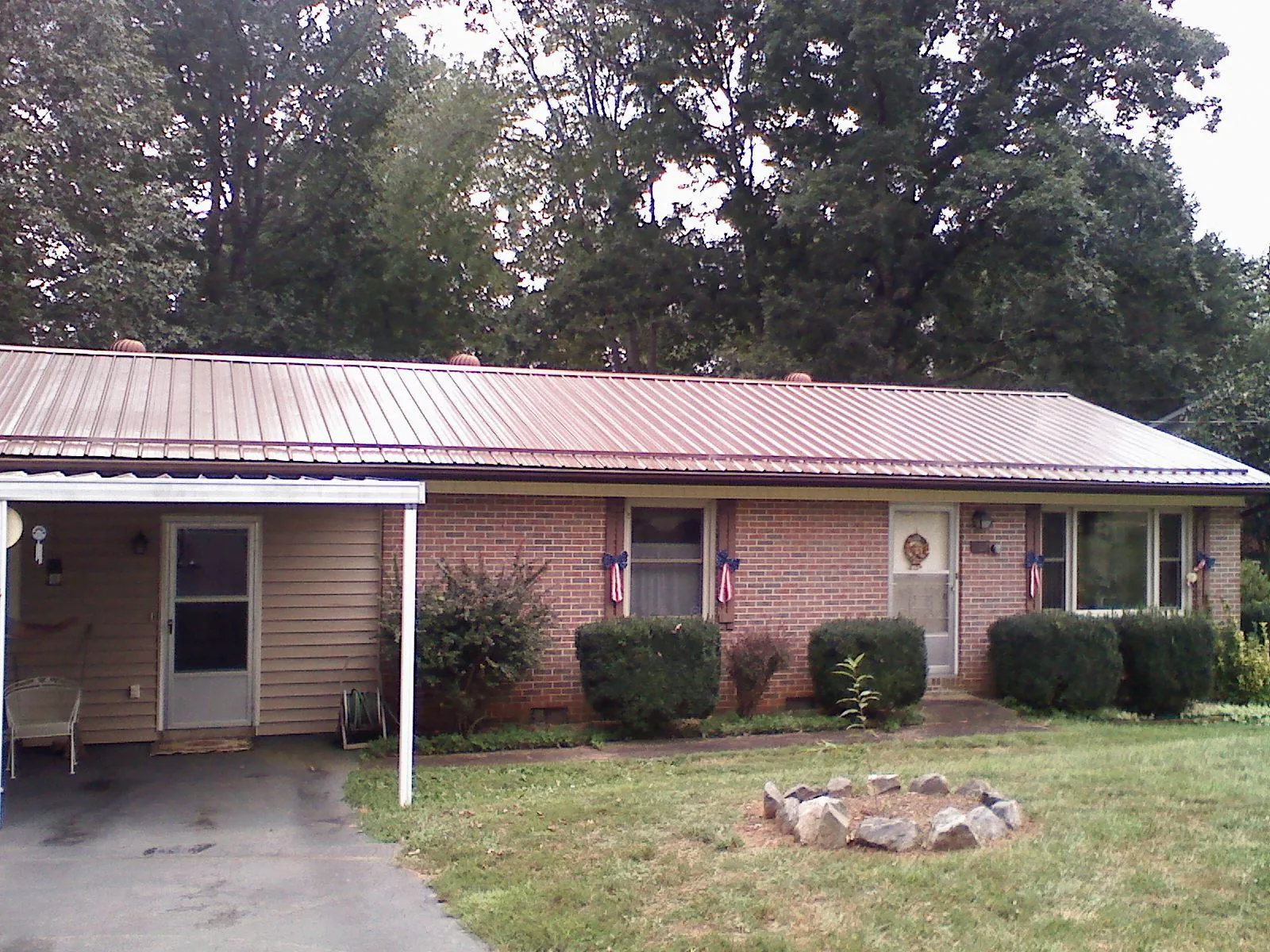 Bronze metal roof and carport on a brick ranch home — Roof Repair work by our crew in Chagrin Falls